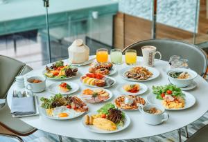 a white table with plates of food on it at Le Meridien Bangkok in Bangkok