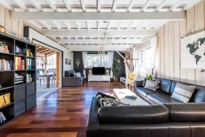 un salon avec un canapé en cuir noir dans l'établissement Maison à 500 m de l'océan Carcans, à Carcans
