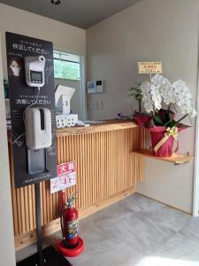 una cocina con una barra con un jarrón de flores en SORAYADO 宙宿, en Tsuru 