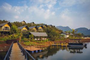 a group of houses on a river with a dock at Canary Islands Resort & Spa in Lonavala