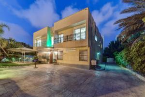 SOKOLOV Vacation Boutique Apartments by the sea in nahariya في نهاريا: مبنى كبير وامامه موقف سيارات