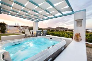 un bain à remous sur la terrasse d'une maison dans l'établissement Luxury Paros Villa 1 Bedroom Villa Vrachian Earth Private Jacuzzi & Beautiful Views Naousa, à Kampos Paros