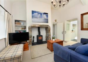 sala de estar con TV y chimenea en Pengarth Cottage, en Abersoch