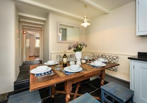 comedor con mesa de madera y sillas en Pengarth Cottage, en Abersoch