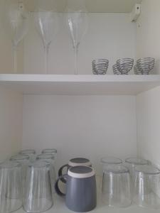 a row of glass stools sitting on a shelf at Whole Apartment with Balcony Breakfast & Parking in Bishop Auckland