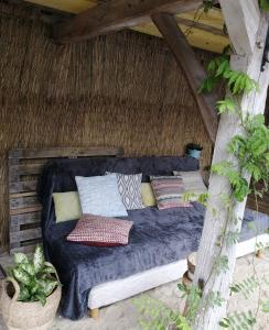 a bed in a thatched room with pillows on it at Martine à la Ferme in Arrest