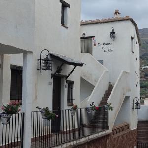 biały budynek ze schodami i drzwiami w obiekcie La Castaña y la Uva 