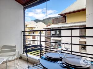 a balcony with a table and chairs and a window at La Riviera - Studio proche du centre de Saint-Denis in Saint-Denis