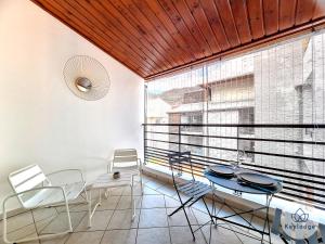 a dining room with a table and chairs and a large window at La Riviera - Studio proche du centre de Saint-Denis in Saint-Denis