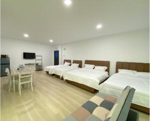 a bedroom with three beds and a table and a tv at CN Homestay A2 Floor 1 at Nagoya Hill Mall in Nagoya