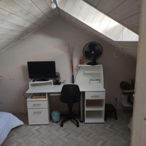 um quarto no sótão com uma secretária, um computador e uma cadeira. em Maison et jardin Nantes Chantenay em Nantes