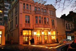 un grand bâtiment avec des personnes debout à l'extérieur dans l'établissement Family Hotel Chiplakoff, à Bourgas