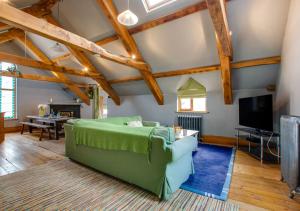 uma sala de estar com um sofá verde e uma televisão em Wall Cottage Group em Tenby
