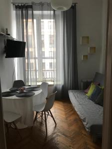 uma sala de estar com uma mesa e cadeiras e uma cama em Apartament Warecka em Varsóvia