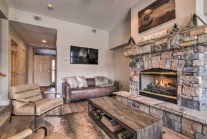 a living room with a large stone fireplace at Waterfront Home with Scenic Views in Silverthorne in Silverthorne