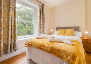 a bedroom with a large window and a bed at Greengrove Farmhouse Glasallt in Llangadog