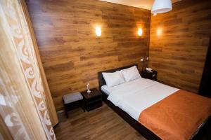 ウラン・ウデにあるHotel Kochevnik na Zherdevaの木製の壁のベッドルーム1室(ベッド1台付)