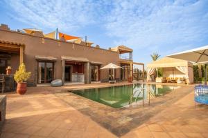 a swimming pool in front of a house at Villa Kenza in Tahannout