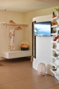 a living room with a flat screen tv and a shelf at Lydia House by Elefthia Syros in Megas Yialos-Nites