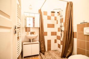 a bathroom with a sink and a shower at Colors Apartment in Budapest