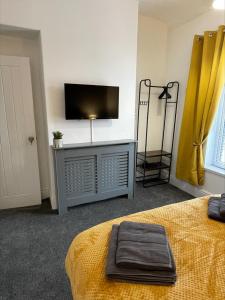 a bedroom with a bed and a flat screen tv at Byelands House in Middlesbrough