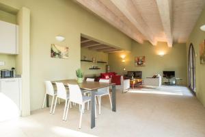 cocina y comedor con mesa y sillas en Deluxe Apartment in Villa Salvia - Cignella Resort Tuscany, en Osteria Delle Noci