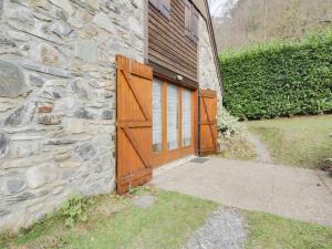 a stone house with a wooden door and a stone wall at Maison Luz-Saint-Sauveur, 3 pièces, 4 personnes - FR-1-402-40 in Luz-Saint-Sauveur