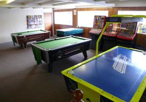 a room with three pool tables and arcade machines at Gowerhaven in Knelston