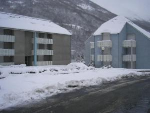 un bâtiment avec de la neige au sol à côté d'une route dans l'établissement Studio Luz-Saint-Sauveur, 1 pièce, 4 personnes - FR-1-402-72, à Luz-Saint-Sauveur