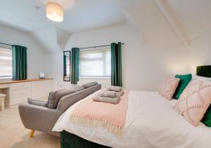 a bedroom with a bed and a couch and a chair at Llety Heulog in Dolgellau