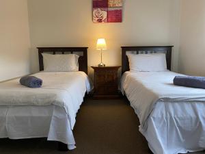 duas camas sentadas uma ao lado da outra num quarto em London Park Resort em Narre Warren