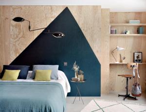 فندق هنرييت في باريس: غرفة نوم بسرير ازرق وبجدار اسود