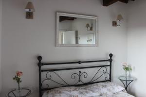 Schlafzimmer mit einem Bett und einem Spiegel an der Wand in der Unterkunft San Bartolomeo Apartment in Pistoia