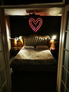 Sweet home San Filippo Industry Style in centro città في بييلا: غرفة نوم مع سرير مع علامة على القلب