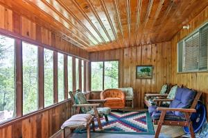 een afgeschermde veranda met schommelstoelen en ramen bij Ruidoso Cabin with Sunroom, Surrounded By Wildlife! in Ruidoso