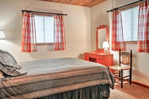 een slaapkamer met een bed, een spiegel en ramen bij Ruidoso Cabin with Sunroom, Surrounded By Wildlife! in Ruidoso