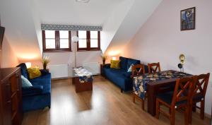 ein Wohnzimmer mit einem blauen Sofa und einem Tisch in der Unterkunft APARTAMENTY TR 11 Apartament nr 6 in Olsztyn