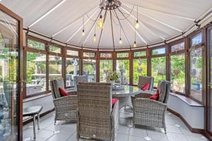 a conservatory with a table and chairs and windows at Home in the Vale Of Evesham in Pershore