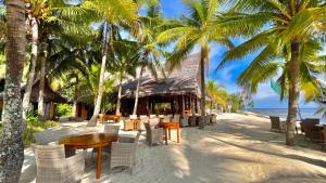een restaurant op het strand met palmbomen bij Coco Grove Beach Resort, Siquijor Island in Siquijor