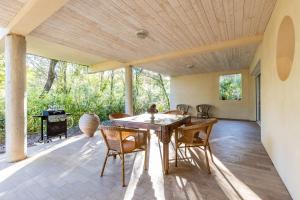 a dining room with a table and chairs on a patio at Appartement Lac de Lacanau in Lacanau