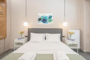 um quarto com uma grande cama branca com duas mesas de cabeceira em Pale Orb Properties (1) em Atenas