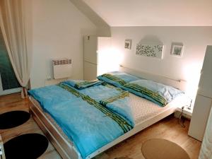 a bedroom with a large bed with blue sheets at Apartmán Romanna in Terchová