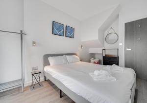 een slaapkamer met een groot wit bed en 2 handdoeken bij Devon Place in The Mumbles