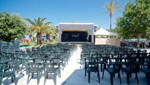 un grupo de sillas y un escenario con una pantalla en Villaggio Le Palme en Ascea