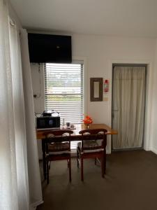 a room with a table and chairs and a window at Serenity Lodge for Couples in Ulladulla