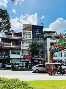a city street with cars and motorcycles and buildings at Asiban Quay Boutique Hotel in Phnom Penh