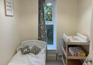 a small bedroom with a crib and a window at Glancoegen in Cemmaes