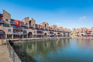 a row of buildings next to a river with houses at City Riverview Apartment with Parking in London