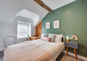 a bedroom with a large bed and a green wall at Tanyrallt in Dinas Mawddwy