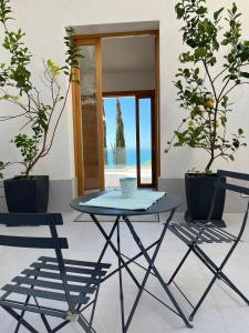 a table and chairs in a room with plants at Il Mare di Giù Boutique Guesthouse in Licata